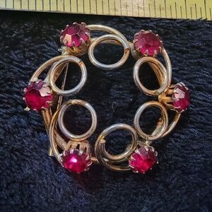 Vintage pin with red rhinestones.